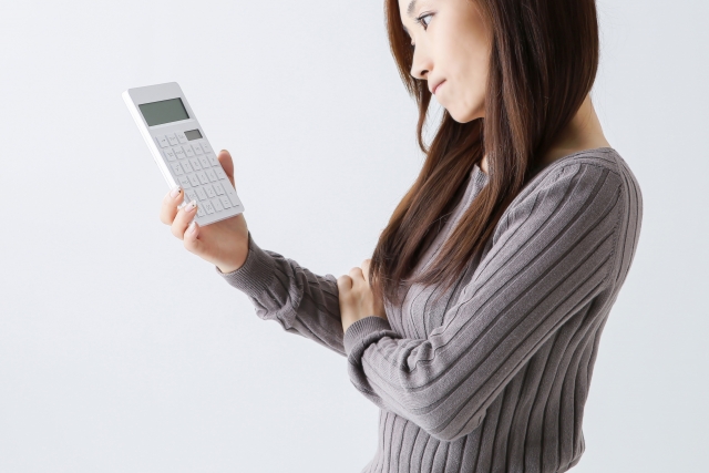 保険外交員の賃金体系について電卓を持ち考える女性